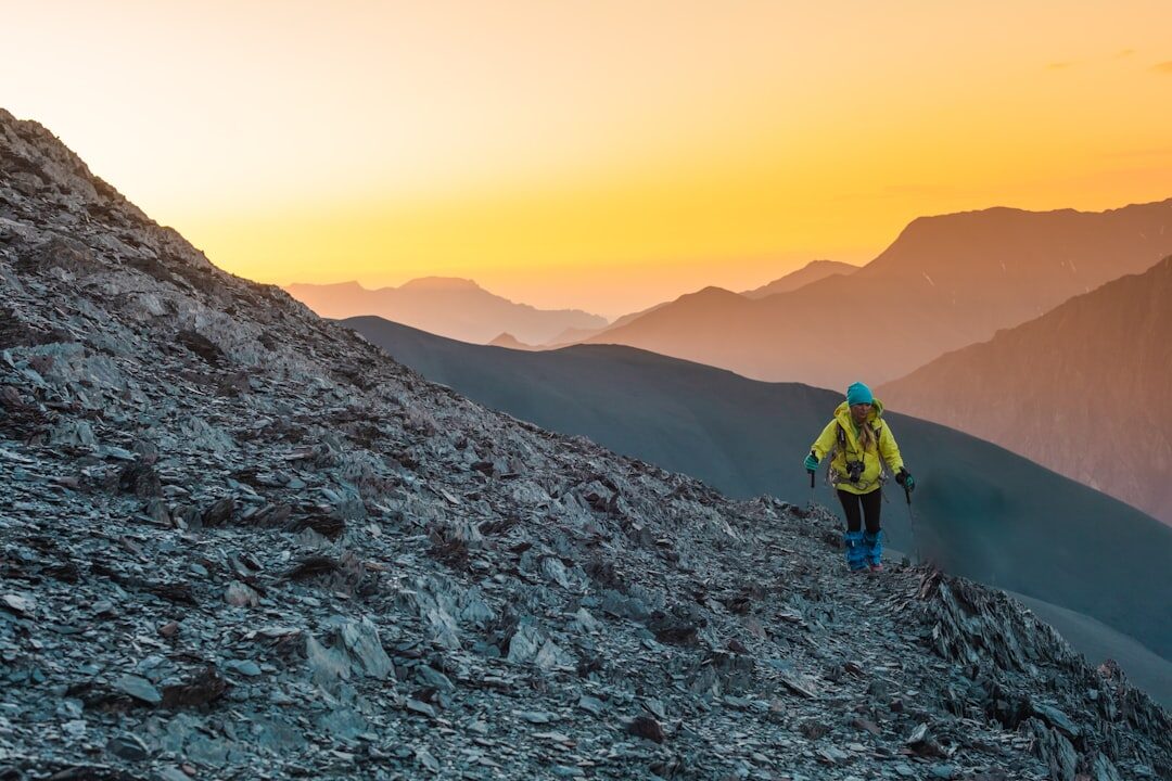 person climbing mountain at sunrise